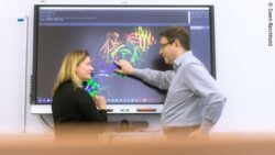 Image: Humboldt-Prof. Dr. Jens Meiler and Dr. Clara T. Schoeder analyse protein structures in front of a big screen; Copyright: Swen Reichhold