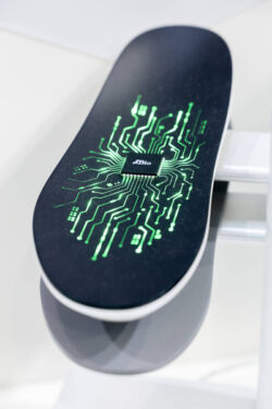Orthopedic insole with a microchip in the center and green-glowing circuit tracks