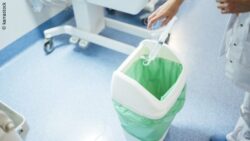Image: Female physician in a hospital is throwing trash into a trash can; Copyright: karrastock
