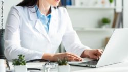Image: a female doctor is sitting in front of a white laptop; Copyright: PantherMedia  / Andrew Lozovyi