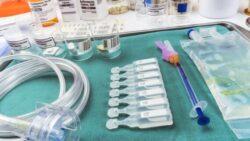 Sorted single-use medical supplies are arranged on a tray on a table