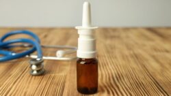 Image: Nasal spray and stethoscope lie on a wooden table 