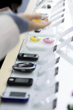 Display featuring various small testing devices at a trade show stand