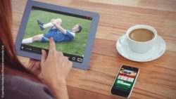 Image: Woman looks at the image of an injured soccer player on a tablet; Copyright: panthermedia.net/Wavebreakmedia Ltd.